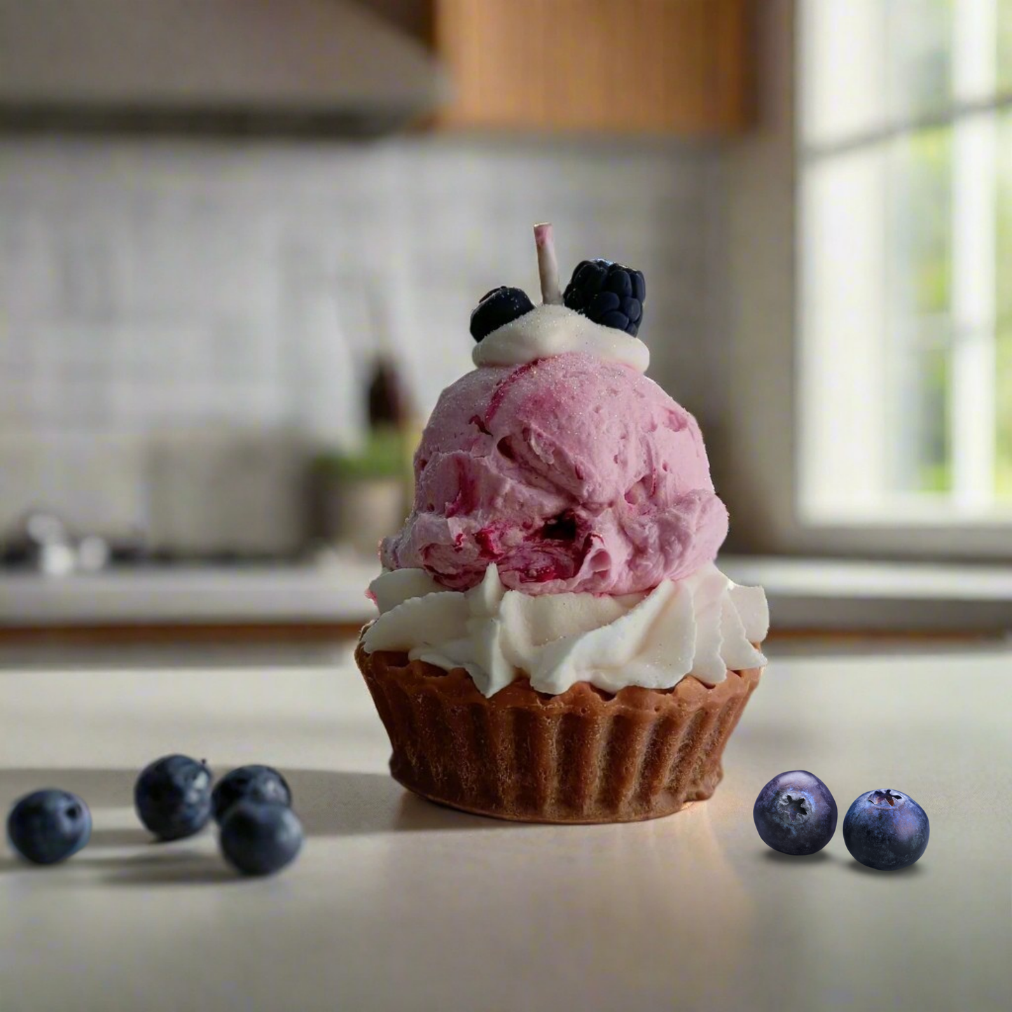 Cupcake with pink ice cream and blueberries on a kitchen counter