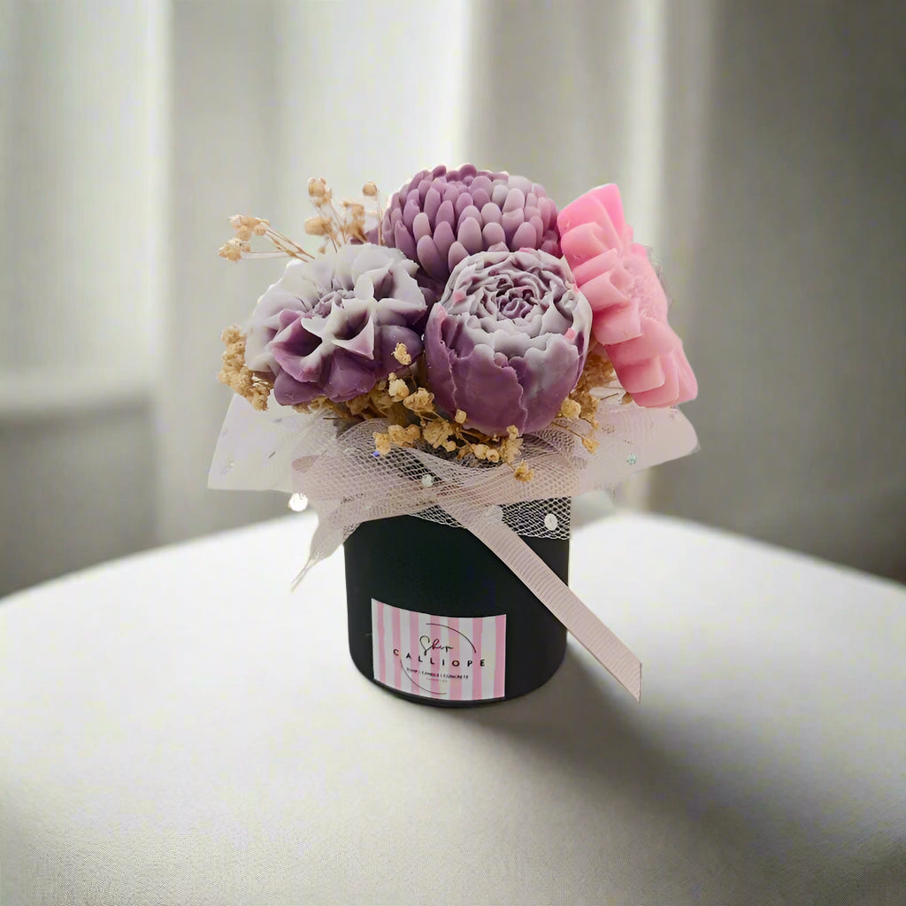 Decorative arrangement of flowers in a black container with a white background