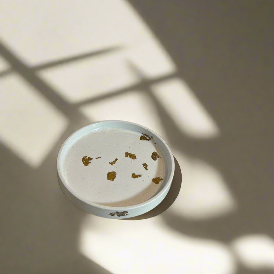 A decorative round porcelain dish with a minimalistic geometric pattern in blue and white colors.