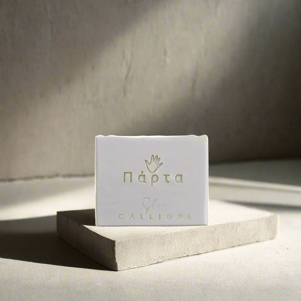 Small white soap with branding on a gray background