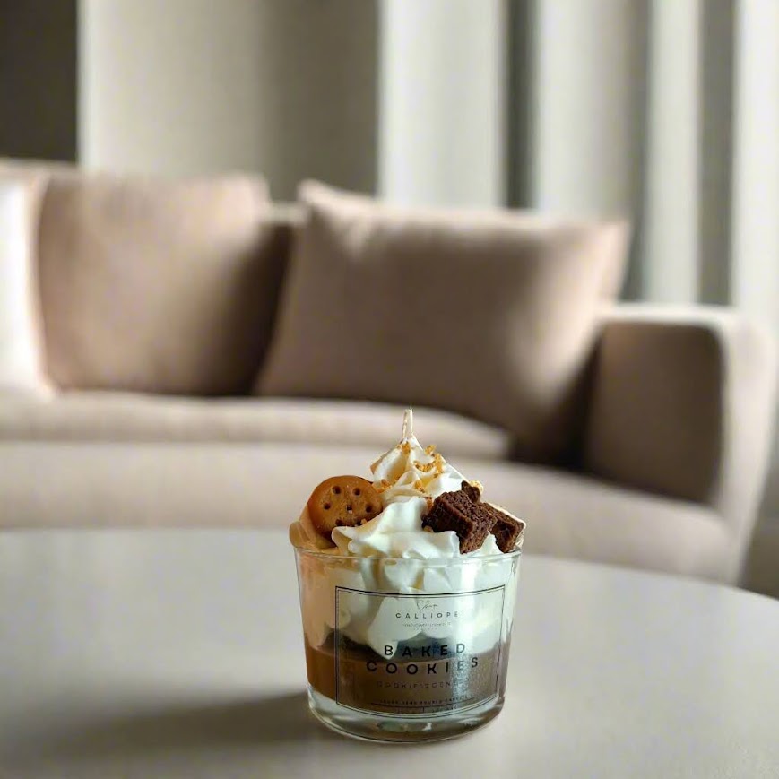 Candle in a glass with whipped cream and cookies on a table with a blurred background