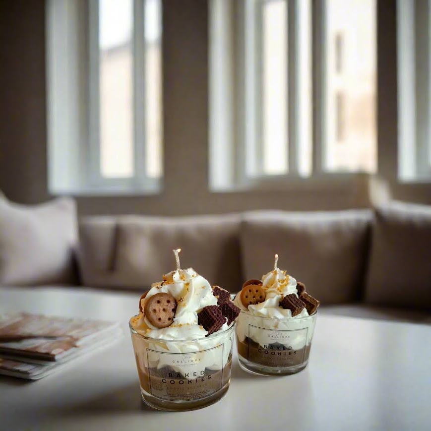 Two dessert candles with whipped cream and cookies on a table with a blurred background