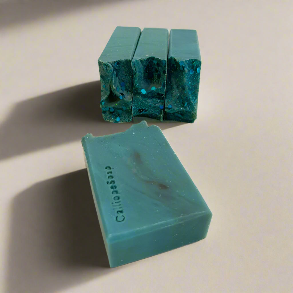 Two green soap bars on a light gray surface