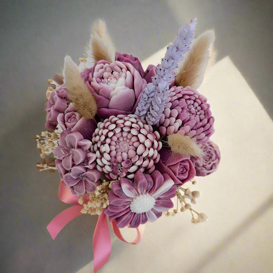 Bouquet of pink and purple flowers with a pink ribbon on a white background