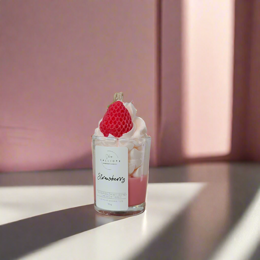 Candle shot with a strawberry on top on a pink background