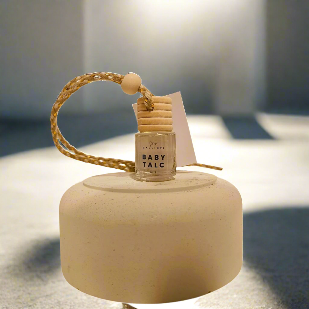 baby talk scented car diffuser with wooden reeds and bead-like details, displayed on a neutral background.