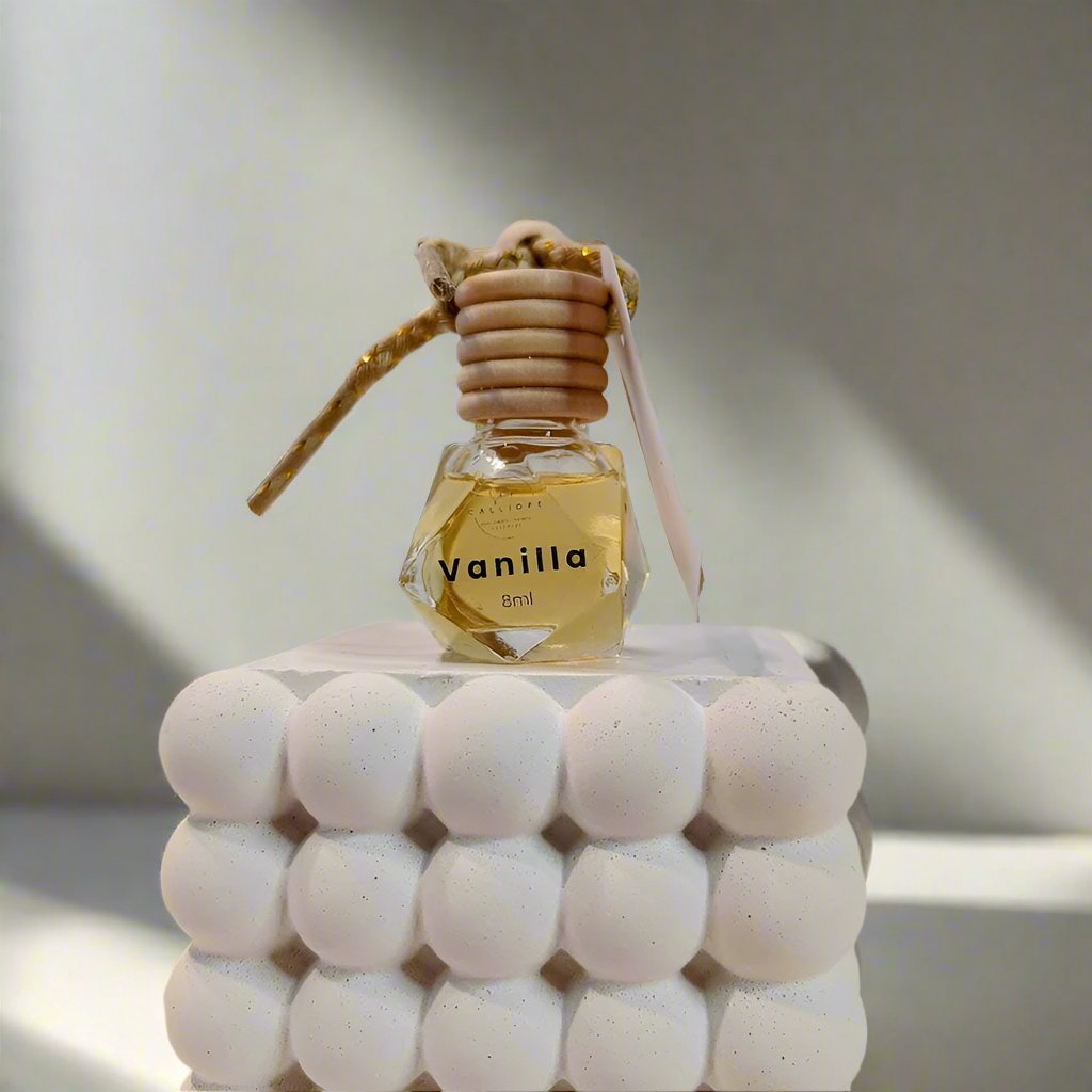 vanilla scented car diffuser with decorative top on a plain background