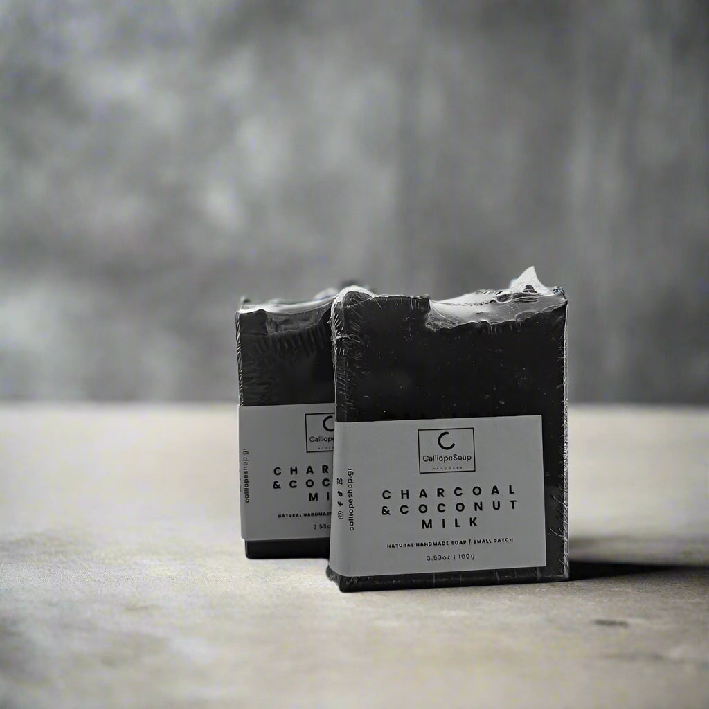 Two bars of Charcoal & Coconut Milk soap on a white surface with a white background