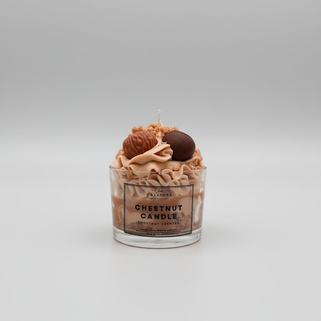 Chestnut candle with decorative elements in a glass container on a light gray background