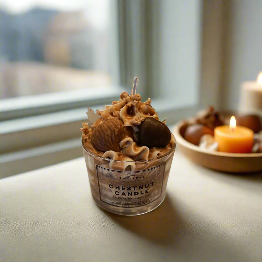 Candle with chestnut decorations in a small container on a white background
