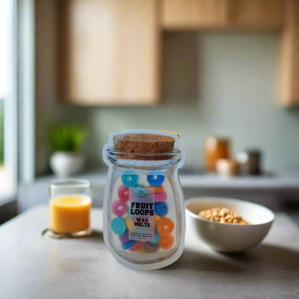 A jar of wax melts with colorful fruit loop shapes, placed on a kitchen countertop near a glass of orange juice and a bowl of cereal.