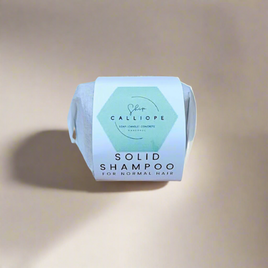 Solid shampoo bar with Calliope label on a beige background
