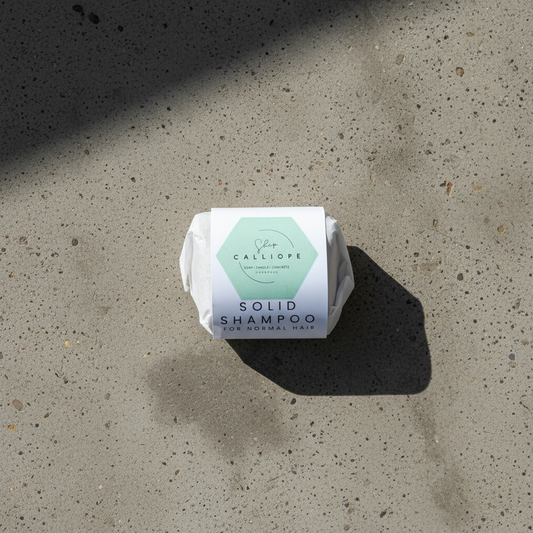 Solid shampoo bar with Calliope label on a beige background