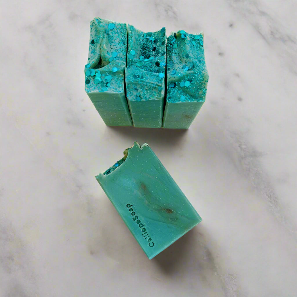 Three green soap bars with a visible brand name on a light background