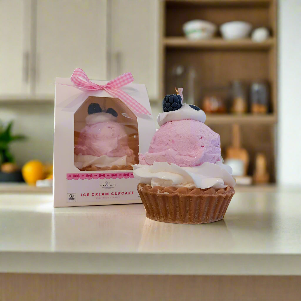 Pink ice cream cupcake candle with packaging on a white background