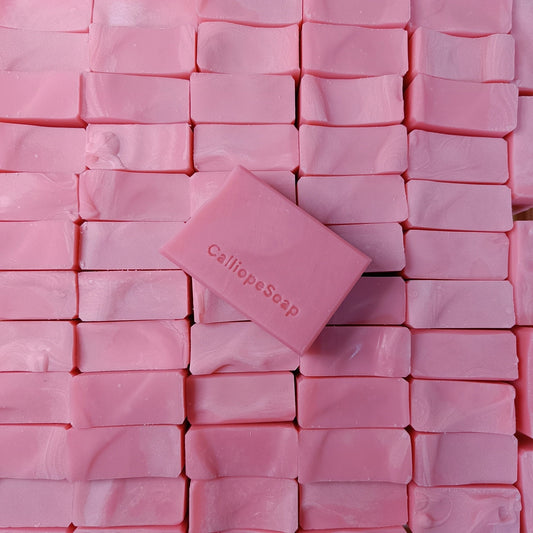 Pink soap bar with 'CalliopeSoap' branding on a background of other pink soap bars.