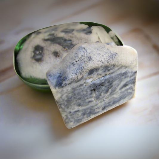 Bar of soap with a green dish on a light background