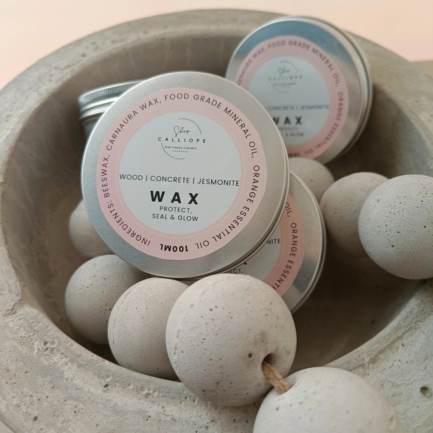 Tins of wax with a label in a concrete bowl