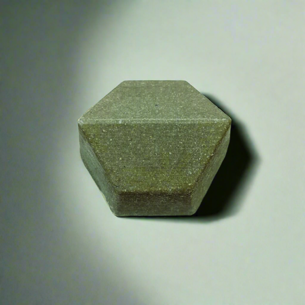 Hexagonal green solid shampoo on a gray background