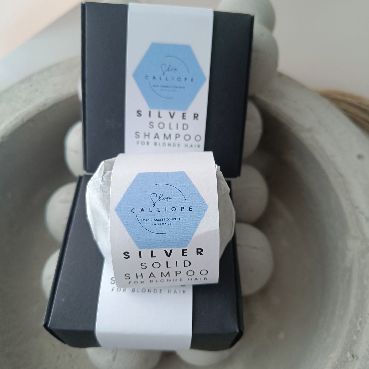 A solid shampoo bar packaged and labeled as silver solid shampoo for blonde hair