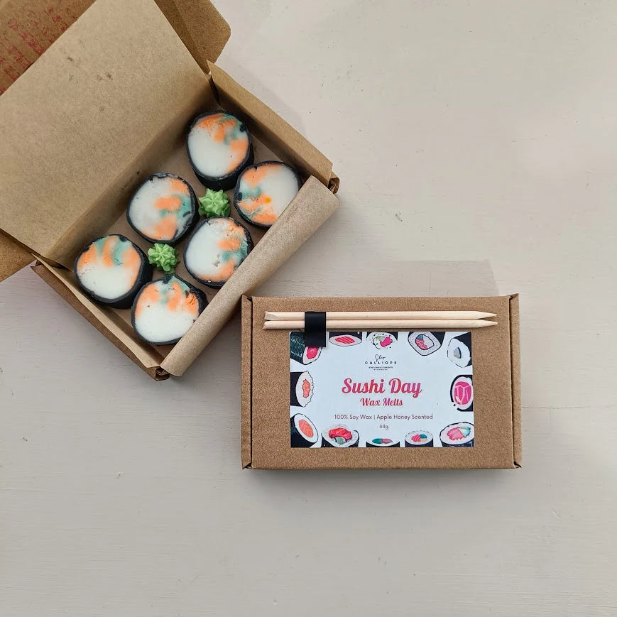 Sushi-shaped wax melts in a cardboard box with a label on a light gray background