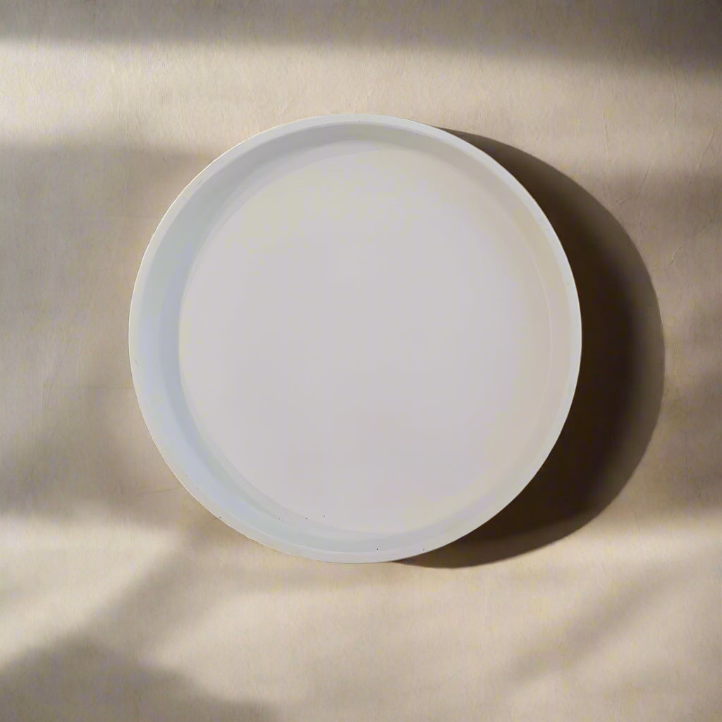 A decorative round porcelain dish with a minimalistic geometric pattern in blue and white colors.