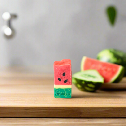 Watermelon-shaped eraser on a wooden surface with watermelons in the background