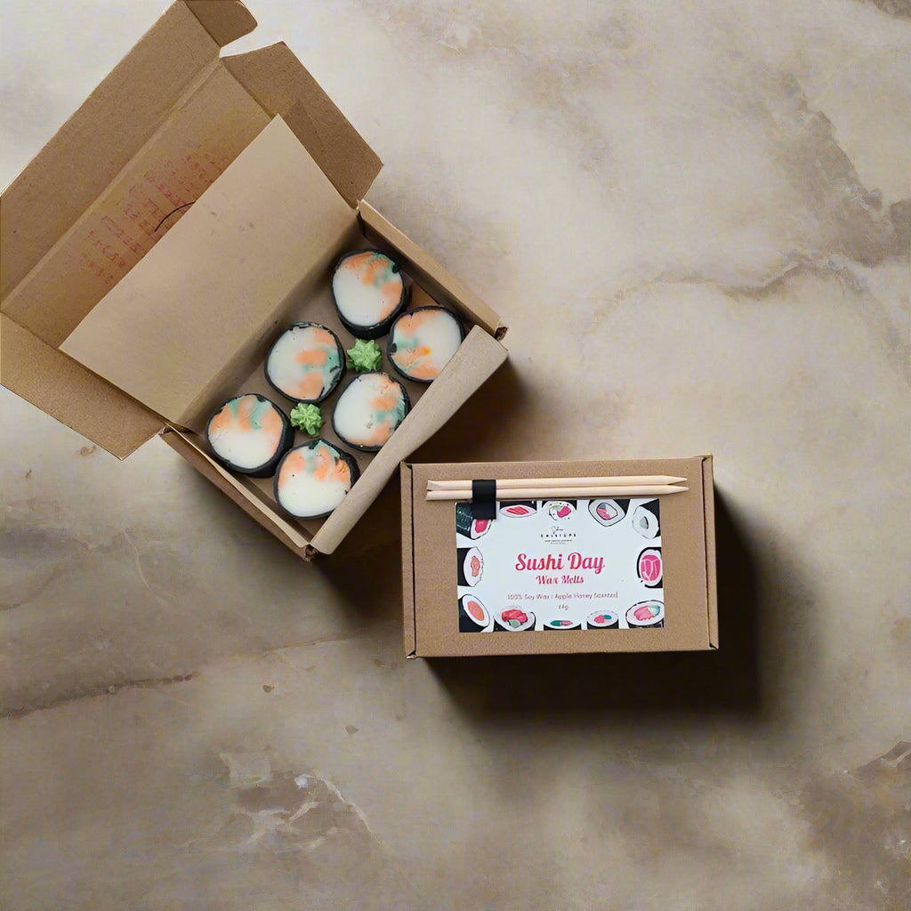 Cardboard sushi box with toy sushi pieces and a small sign labeled 'Sushi Day' on a light background.