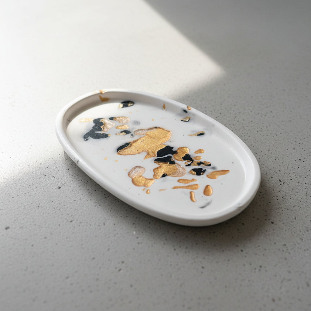 A white oval ceramic dish or plate with a glossy finish on a concrete surface.