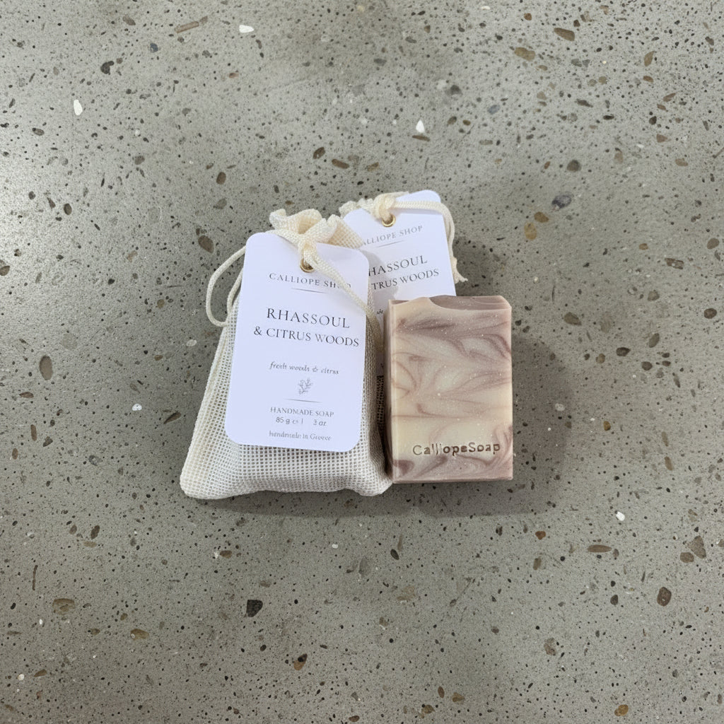 Bar of soap with pounch packaging and a label on a surface