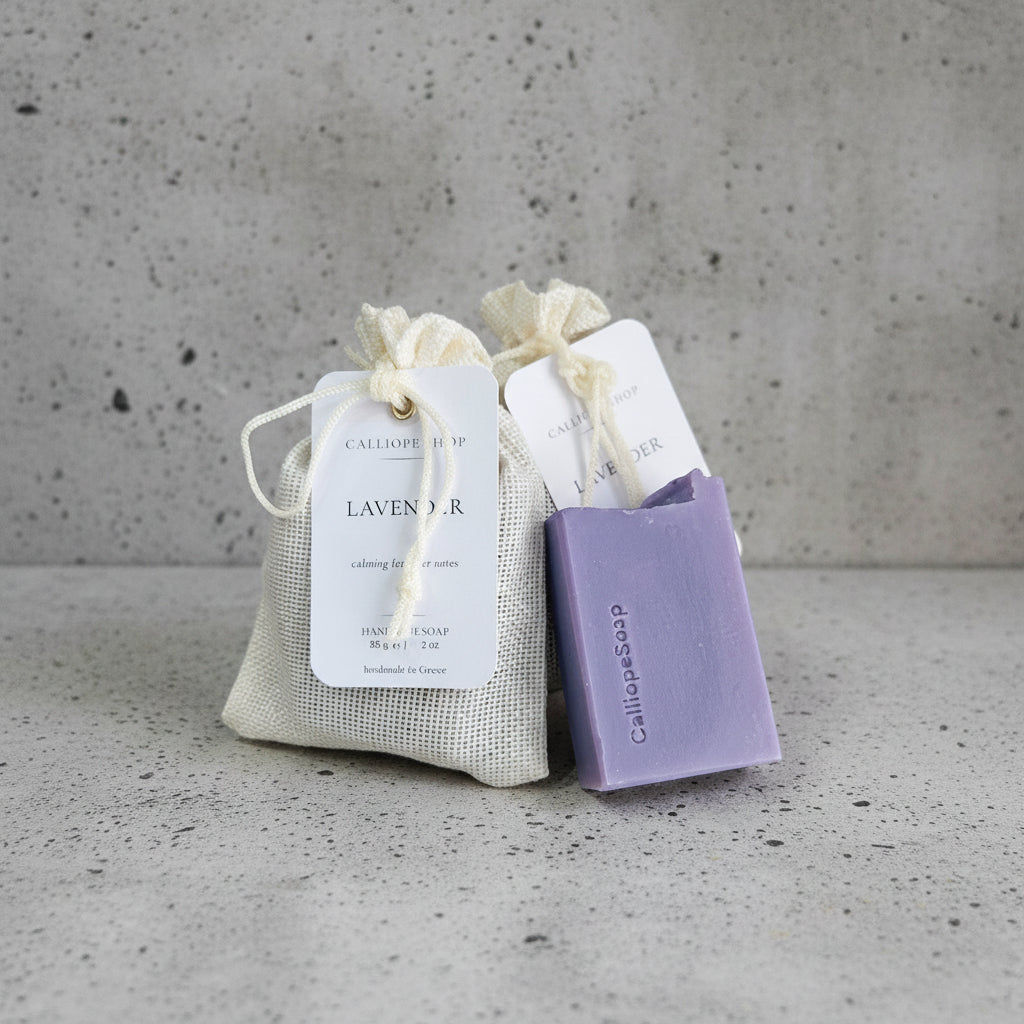 Purple soap bar with a drawstring bag labeled 'Lavender' on a white surface.