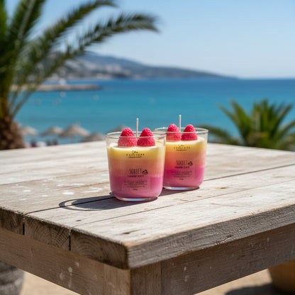 Two colorful sorbet-themed candles with raspberries on a surface.
