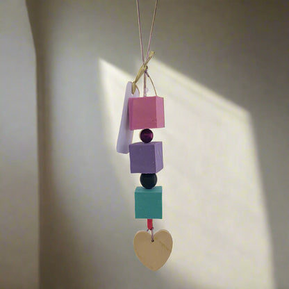 Colorful soap beads with a heart on a light purple background