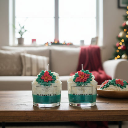 Two Alexandrino candles with floral designs on a wooden table in a living room setting.