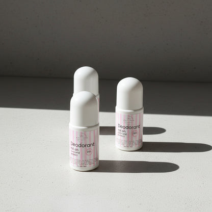 Three deodorant bottles on a light surface with a gray background