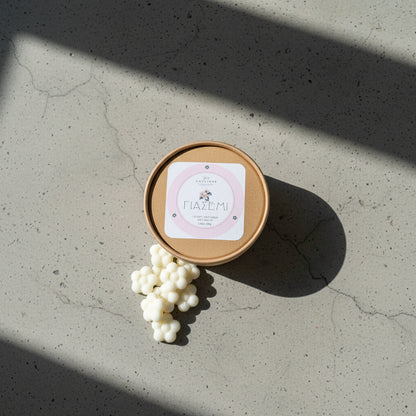 Κάτοψη από αρωματικά λευκά λουλούδια wax melts γιασεμί και το craft κουτί τους σε γκρι φόντο