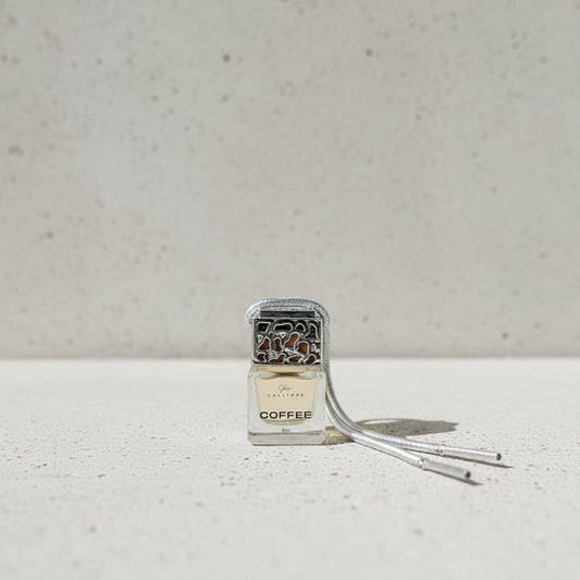 Coffee-scented car diffuser with decorative top on a plain background