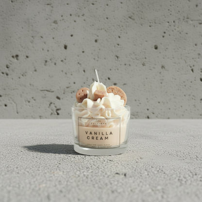Χειροποίητο κερί Vanilla Cream σε γυάλινο ποτήρι, φωτογραφημένο πάνω σε τραχιά επιφάνεια τσιμέντου.