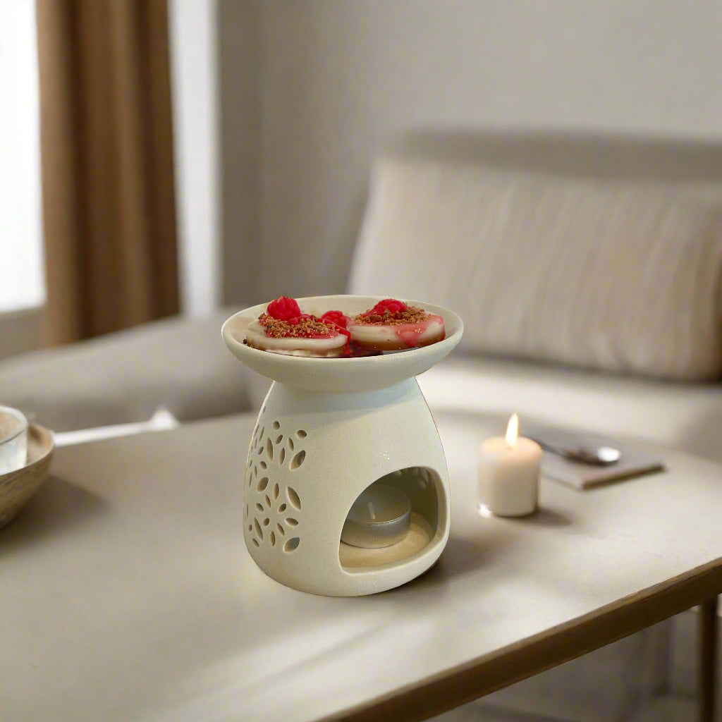 Λευκός αρωματιστής με wax melts πάνω σε ξύλινη επιφάνεια σε σκοτεινό σαλόνι