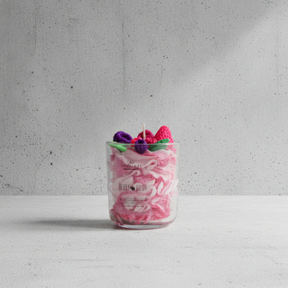 Candle in a glass jar with decorative elements on top, labeled 'Berry Rush'.