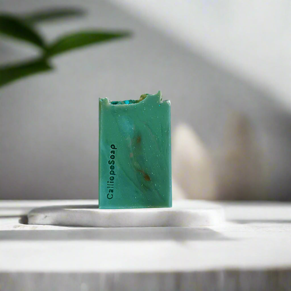Green bar of soap with 'Calliope Soap' branding on a white background