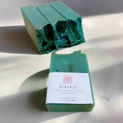 Green soap bars with a label on a beige surface