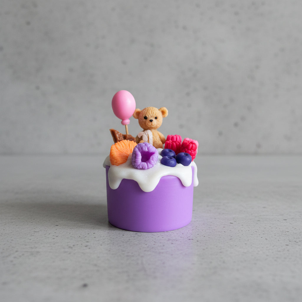 Small purple cake candle with a teddy bear, balloon, and colorful fruits on top