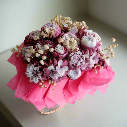 Bouquet of decorative flowers with pink and white tones on a white surface.