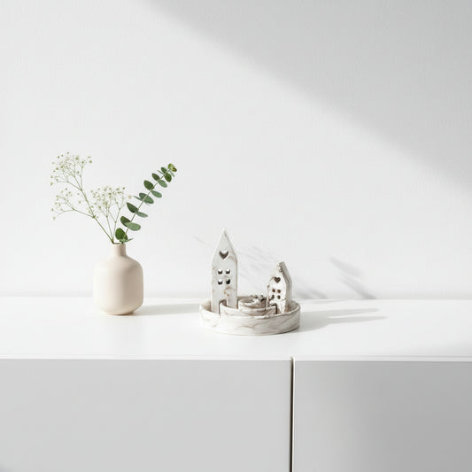 White candle holder with architectural design on a beige surface
