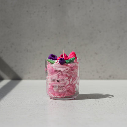 Candle in a glass jar with decorative elements on top, labeled 'Berry Rush'.