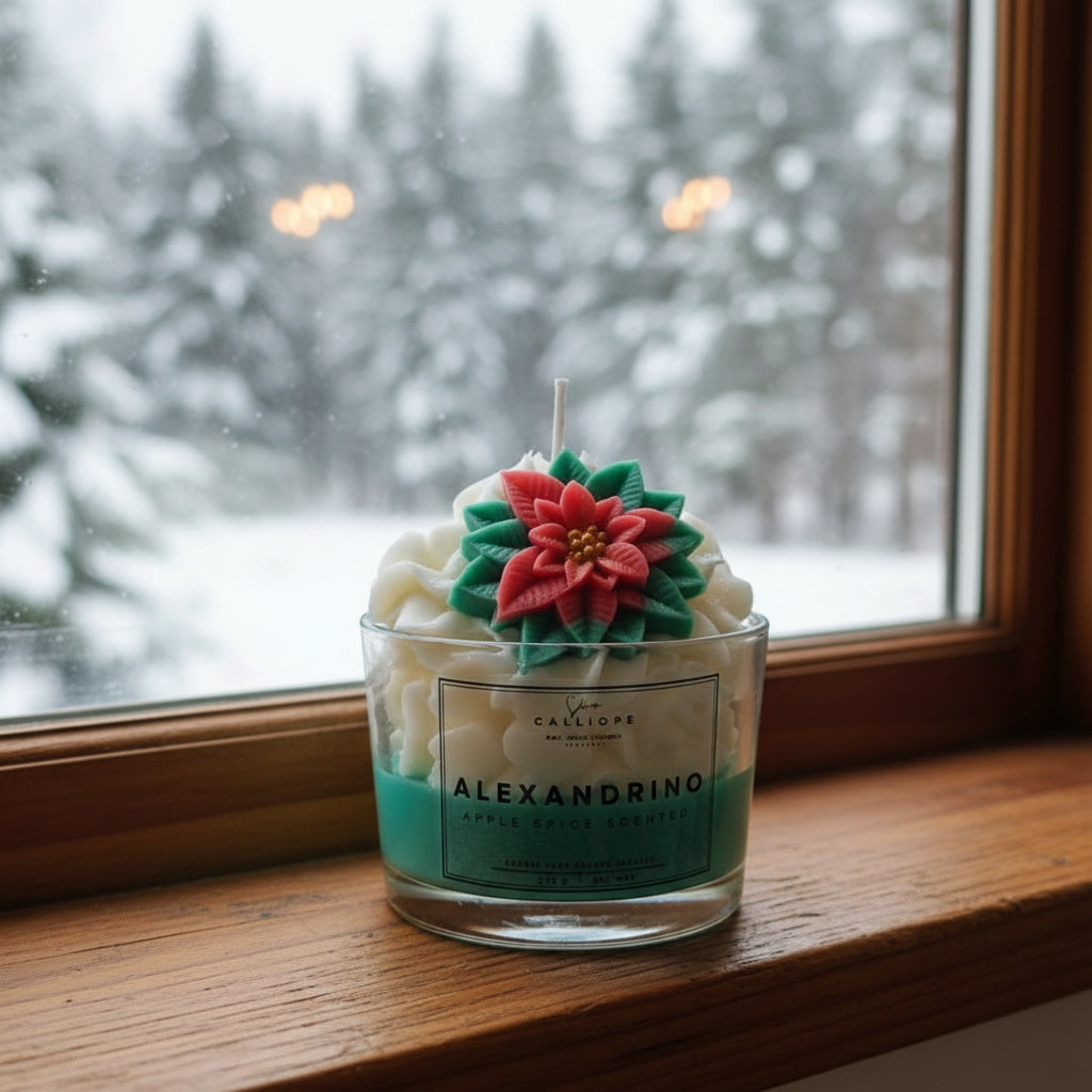 Candle with floral design on a windowsill with a snowy outdoor view