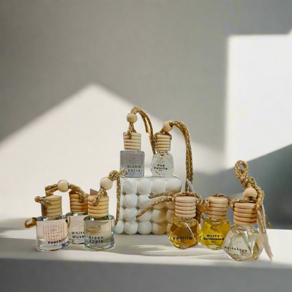 A collection of car diffusers with wooden reeds and bead-like details, displayed on a neutral background.