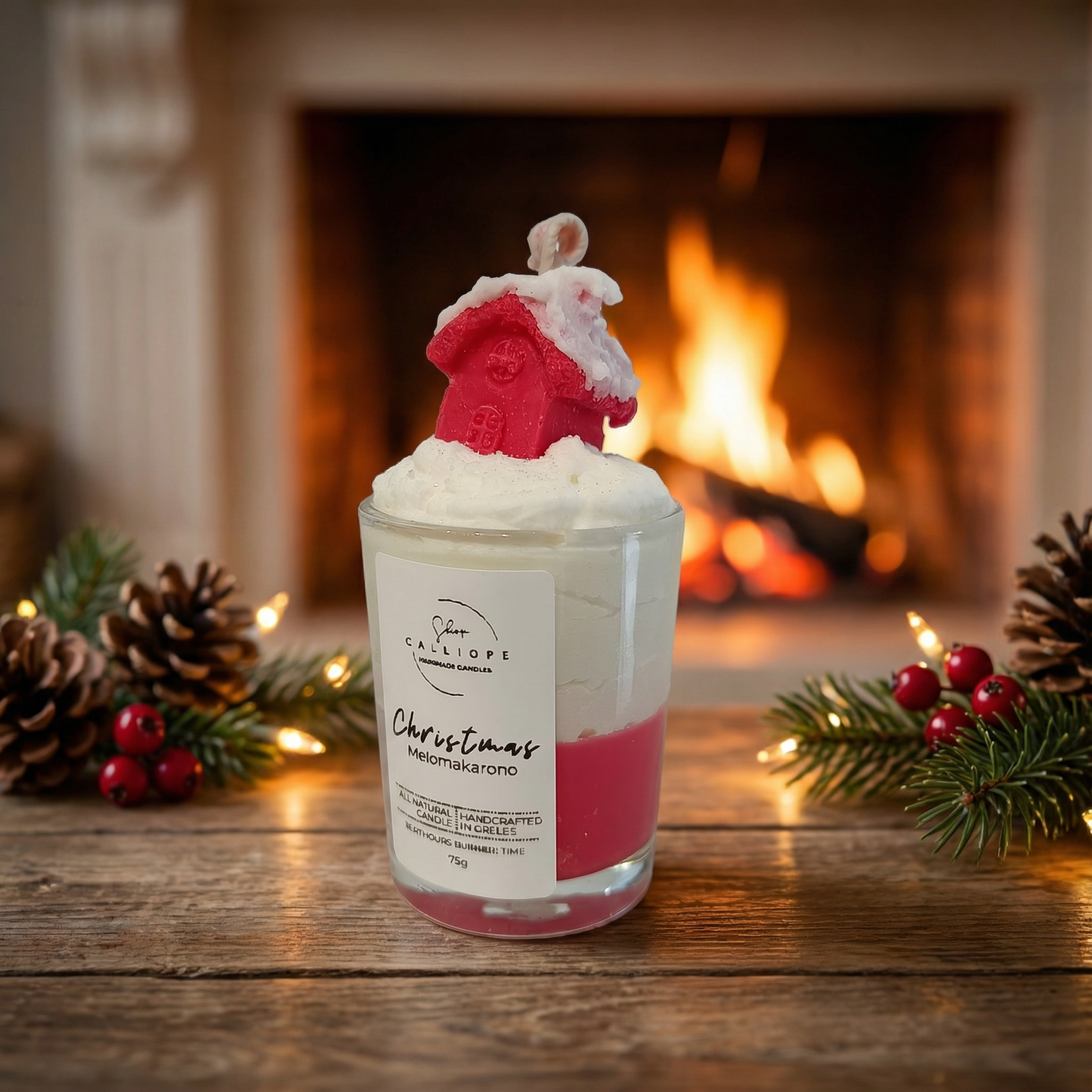 Candle with a Christmas-themed design in front of a fireplace