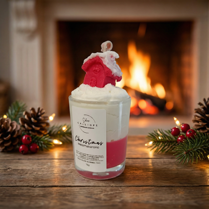 Candle with a Christmas-themed design in front of a fireplace